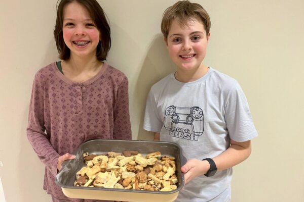 Foto von zwei Kindern mit frisch-gebackenen Keksen