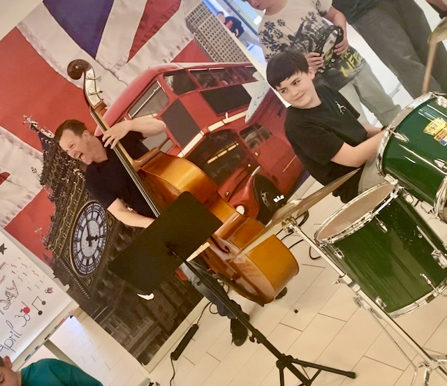 Foto vom Direktor Glanzner und einem Kind beim Spielen in der Band